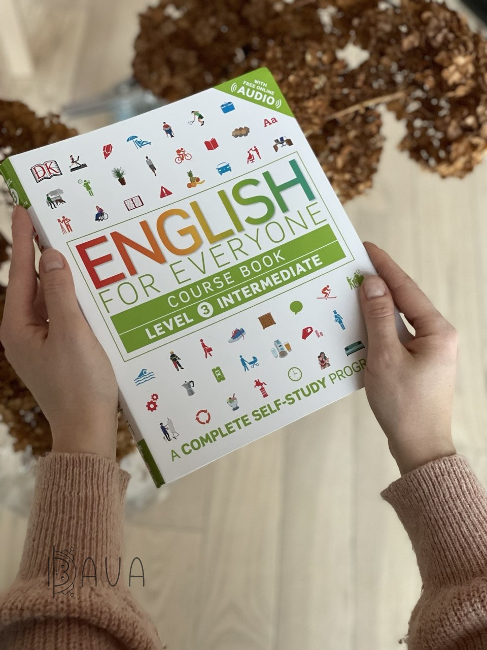 Посібник English for Everyone Course Book для рівня Level 3 Intermediate в руках на затишному тлі.